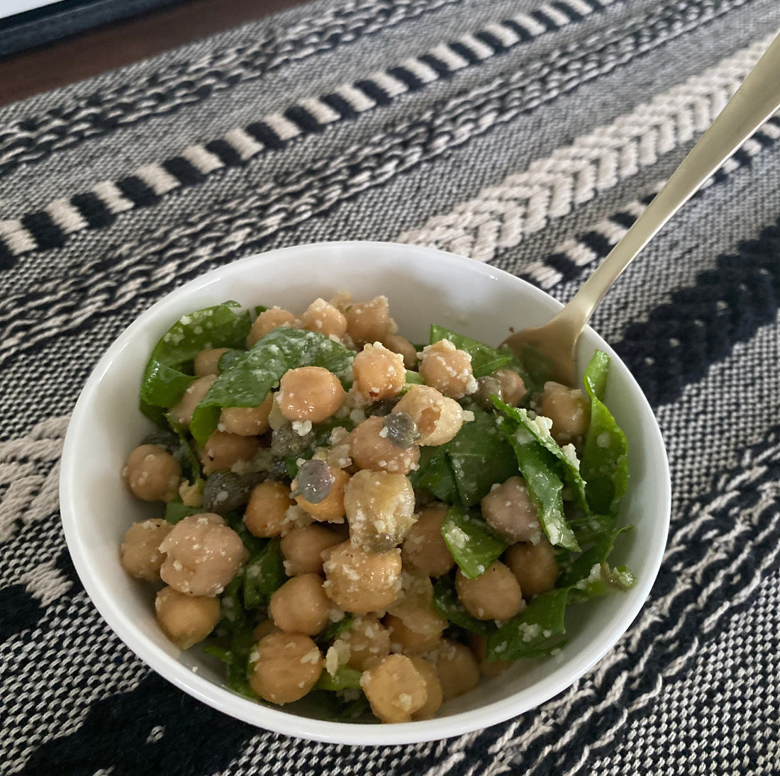 chickpea salad with caper vinaigrette and garden fresh spinach in a bowl