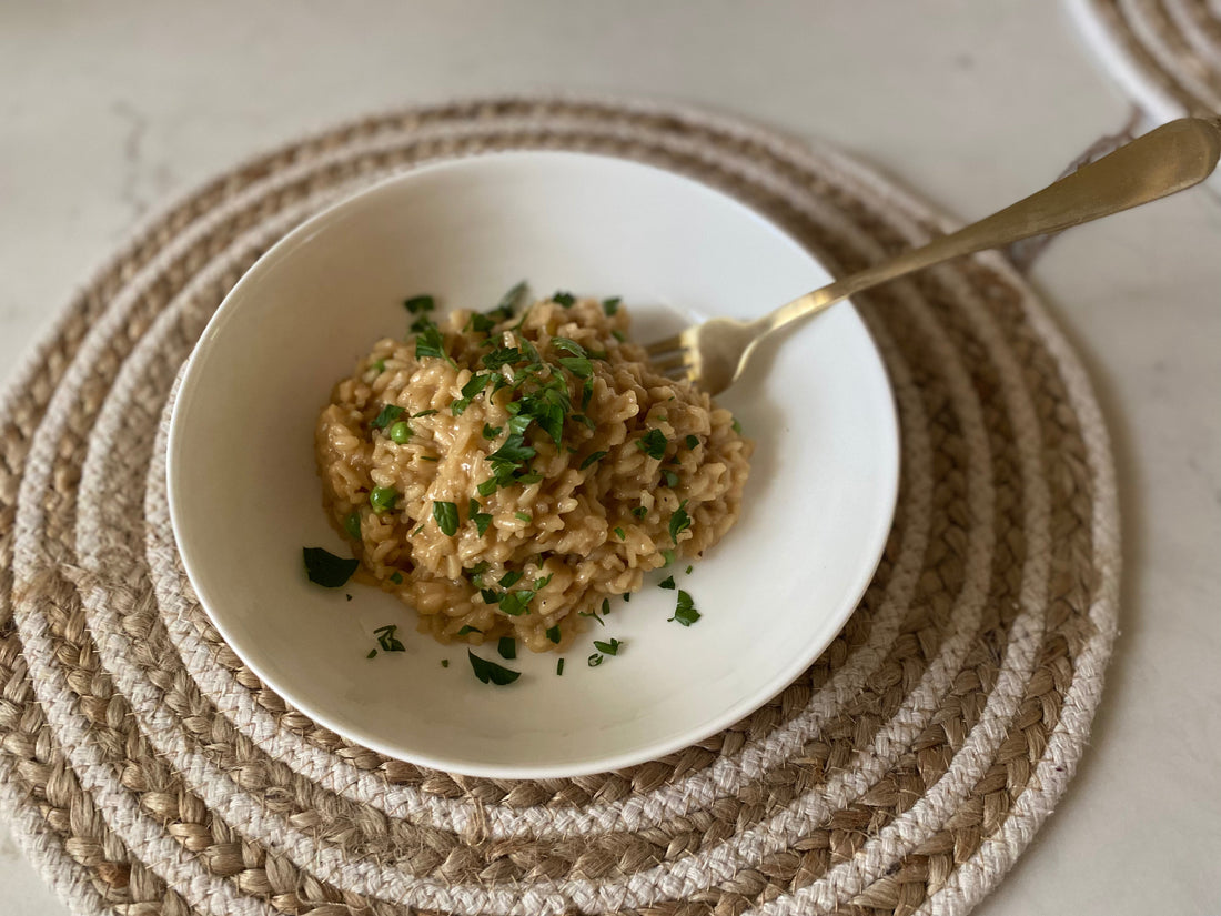 Garden pea risotto with egyptian walking onions in a bowl topped with parsley